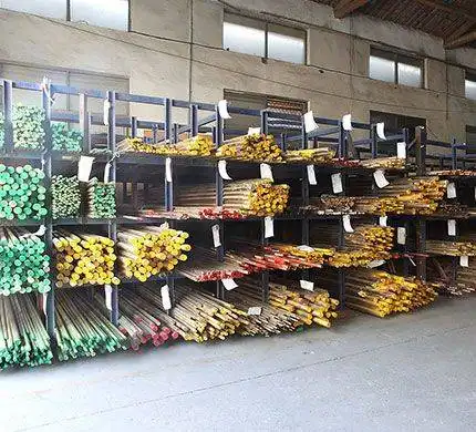Metal rods and bars organized on racks in an industrial warehouse.