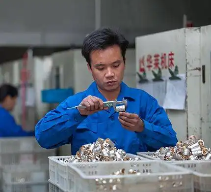 A factory worker inspecting a metal component with a caliper.